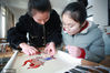 2021年1月18日，江苏省扬州市特殊教育学校的聋哑学生们在老师的指导下制作刺绣作品。 
