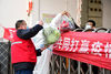 2021年1月11日，在河北省石家庄新乐市一小区门口，志愿者在给小区居民送蔬菜。
