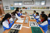 2021年10月12日，山东青岛城阳区仲村小学，孩子们跟随老师学习版画拓印。