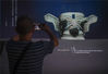 2021年10月13日，杭州，“人与神——神秘的古蜀文明”展览正在西湖边浙江西湖美术馆展出，包括三星堆遗址文物在内的139件/组展品吸引民众参观。参观者在拍摄三星堆文物纵目面具（复制品）。