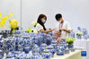 　10月15日，一名国内采购商（左）在第130届广交会瓷器展台洽谈。新华社记者 刘大伟 摄