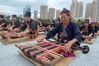 2021年10月16日，在海南省东方市文化广场，千名身着传统服装的黎族妇女熟练织黎锦秀技艺。