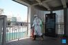 A fireman disinfects the entrance of a skywalk in Xiamen, southeast China's Fujian Province, Oct. 5, 2021. Outdoor public places in Xiamen started to reopen from Oct. 5, as the results of the sixth round of citywide nucleic acid testing all came out negative. (Photo by Zeng Demeng/Xinhua)