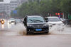 2021年10月8日，海南省琼海市出现大到暴雨，市民冒雨出行。
