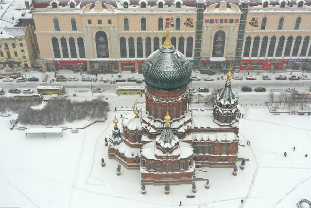 哈尔滨街道在雪中洁白如银 索菲亚教堂红砖绿顶煞是迷人