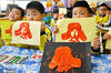 2021年3月4日，山东省烟台市福山区实验幼儿园小朋友们在展示拓印的雷锋肖像。