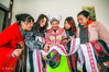 2019年11月5日，在贵州省毕节市大方县奢香古镇，杨文芬（中）正在给邻居介绍苗族服饰。