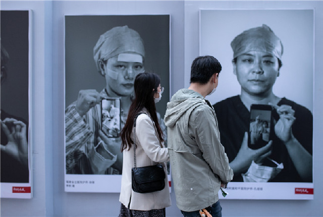 武汉举办“相约春天”抗击疫情摄影展 吸引众多游客观展