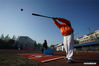 Tseng Chun-an (R) hits the ball during a baseball training session in Xinji Center Primary School in Yizheng, east China's Jiangsu Province, April 9, 2021. Born in a 