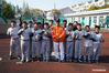 Tseng Chun-an (C) poses for a photo with his students at a baseball training session in Xinji Center Primary School in Yizheng, east China's Jiangsu Province, April 9, 2021. Born in a 