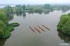 Aerial photo taken on April 27, 2021 shows that locals row dragon boats at Qinhu Lake in Taizhou, east China's Jiangsu Province. Local authorities in Taizhou City have been promoting sports tourism by building sports centers in wetlands, ball games centers, physical development training camps and other sports venues to boost local tourism market. (Xinhua/Yang Lei)