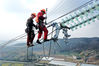 2020年12月10日上午，浙江省舟山市岱山县境内的220千伏蓬莱-鱼山输电工程7至18号塔间，电力工人在高塔上进行输电导线搭接安装。