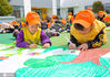 2021年4月7日，在江苏省如皋市外国语学校附属幼儿园操场上，小朋友在用画笔绘出心中的美丽春天。
