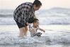 2021年5月10日，海南三亚，家长带着孩子在三亚湾戏水。
