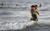 2021年5月10日，海南三亚，家长带着孩子在三亚湾戏水。

