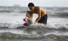 2021年5月10日，海南三亚，家长带着孩子在三亚湾戏水。
当日，海南省多个市县发布高温四级预警，许多市民和游客纷纷来到戏水，乐享清凉。来源：视觉中国
