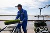 A staff member fills an unmanned transplanter with rice seedlings in a smart agriculture demonstration zone administered by Hongwei Farm Co., Ltd. of Beidahuang Group in northeast China's Heilongjiang Province, May 11, 2021. Equipped with a self-driving system based on the Beidou Navigation Satellite System (BDS), the smart transplanter can independently finish rice transplanting, avoid obstacles and turn around when needed. (Xinhua/Zhang Tao)