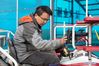 A staff member sets working route for an unmanned transplanter on a vehicle-mounted terminal tablet in a smart agriculture demonstration zone administered by Hongwei Farm Co., Ltd. of Beidahuang Group in northeast China's Heilongjiang Province, May 11, 2021. Equipped with a self-driving system based on the Beidou Navigation Satellite System (BDS), the smart transplanter can independently finish rice transplanting, avoid obstacles and turn around when needed. (Xinhua/Zhang Tao)