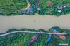 In this aerial photo, Zhao Shibin ferries villagers in Huangdong Yao Township of Hezhou City, south China's Guangxi Zhuang Autonomous Region, May 13, 2021. Waiting by the river has been the daily routine of Zhao Shibin for the past 19 years. Zhao, 61, is a ferryman from Huangdong Yao Township in the city of Hezhou, south China's Guangxi Zhuang Autonomous Region. Separated by the Huangdong River, locals who live in the east bank can only be ferried to reach the west bank, where village markets and medical institutions are located. Knowing that the biggest obstacle to people's life was nature itself, Zhao started to ferry residents in 2002 by pulling the iron-clad boat with a rope through the 105-meter waterway. He has therefore gained the nickname 