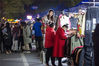 2020年12月5日，杭州，乔司夜市，赵静站在自己的“乔司一枝花”女装摊位前的凳子上，卖力吆喝，招徕顾客。
