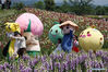 Cartoon characters pose for photos with tourists in the flower fields in Jingshan township of Yuhang district in Hangzhou, capital of East China's Zhejiang province, on May 2, 2021. [Photo/Xinhua]