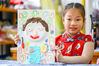 As Father's Day approaches, children at Donggao Kindergarten in Nantong City, Jiangsu Province draw portraits for father with paintbrush and clay on Jun. 18. (CFP Photo) 