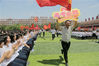 2018年5月24日，河北衡水二中的高三老师举着“高考必胜”的牌子绕场跑为学生们打气加油。闫楠/视觉中国