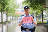 2018年6月9日，在江苏如皋第一中学考点外，一名交警拿着印有“必胜”的红纸为考生加油。徐慧/视觉中国