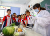 2021年6月21日，在江苏南通如皋市安定小学，工作人员正在为学生现场演示蔬菜农药快检全流程。
