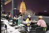 People have dinner on the terrace of a restaurant next to the Dayan Pagoda Square in Xi'an, Shaanxi province, as businesses reopen on March 23, 2020. [Photo/Xinhua]