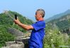 Zhang Heshan takes pictures of the scenery of the Zhengguanling Great Wall in Qinhuangdao, north China's Hebei Province, July 7, 2021. Zhang Heshan, 66, is a villager of Chengziyu, where lies a section of China's Great Wall dating back to Ming Dynasty (1368-1644). Since 1978, Zhang has been a protector of the Great Wall. Over the years, he patrolled the wild Great Wall near his village and never been held back by various challenges, such as blizzards, rainstorms, wild bees and snakes. He has persuaded the herdsmen to leave, scared away the brick-stealers, stopped tourists from making carvings on the Wall, and reported damages. 