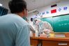 Wang Yu (R) takes a swab sample from a resident for COVID-19 test at a testing site of Longxi Community in Jiangning District of Nanjing, capital of east China's Jiangsu Province, July 25, 2021. A second round of COVID-19 nucleic acid test was launched Saturday night in Jiangning District of Nanjing. Wang Yu, a nurse from Dongshan Community Hospital in Jiangning District, was racing against time in epidemic battle on Saturday night. Wang, along with other medical workers and community workers, has been busy conducting nucleic acid tests for the residents until late night. (Xinhua/Li Bo)