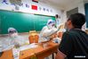 Wang Yu (C) takes a swab sample from a resident for COVID-19 test at a testing site of Longxi Community in Jiangning District of Nanjing, capital of east China's Jiangsu Province, July 25, 2021. A second round of COVID-19 nucleic acid test was launched Saturday night in Jiangning District of Nanjing. Wang Yu, a nurse from Dongshan Community Hospital in Jiangning District, was racing against time in epidemic battle on Saturday night. Wang, along with other medical workers and community workers, has been busy conducting nucleic acid tests for the residents until late night. (Xinhua/Li Bo)