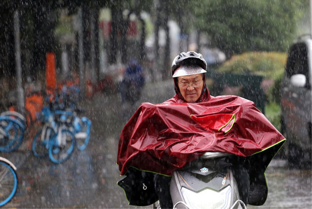 台风“烟花”持续影响南京 市民冒雨出行