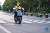 Zhong Jian rides on a road to deliver takeout food in Guangling District of Yangzhou, east China's Jiangsu Province, Aug. 21, 2021. Zhong Jian, 41, a Yangzhou native, has been a food deliveryman for nearly two years. During the recent COVID-19 resurgence in the city, Zhong stuck to his post, delivering takeout food to customers. (Xinhua/Li Bo)