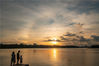 2021年9月9日，海南省琼海市，游人在万泉河畔观光落日美景。