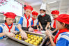 2021年9月10日，浙江省湖州市长兴县洪桥镇中心小学，孩子们正在体验手工制作传统月饼，将月饼赠送给老师。