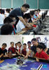 Combo photo shows Yang Sen giving a computer lesson at Heping Primary School (up) and Yang Sen (2nd R) instructing his students at the robot club at Heping Primary School in Hefei City, east China's Anhui Province, Sept. 8, 2021. Yang Sen, a computer teacher from Heping Primary School, has interest in graphical language applied to robots in his spare time. After class, he organizes a robot club instructing his students to explore the use of multiple sensors and various scientific principles. (Xinhua/Zhou Mu)