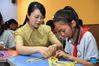 Zhao Xun (L) instructs a student in knitting techniques at the knitting club at Luogang Primary School in Hefei City, east China's Anhui Province, Sept. 8, 2021. Zhao Xun, a teacher of Chinese from Luogang Primary School, also a knitting enthusiast, sets up a knitting club and teaches her students handwork knitting during after-school time. (Xinhua/Zhou Mu)