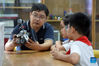 Yang Sen instructs his students at the robot club at Heping Primary School in Hefei City, east China's Anhui Province, Sept. 8, 2021. Yang Sen, a computer teacher from Heping Primary School, has interest in graphical language applied to robots in his spare time. After class, he organizes a robot club instructing his students to explore the use of multiple sensors and various scientific principles. (Xinhua/Zhou Mu)