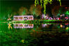 2021年9月15日，江苏苏州，人们在光影璀璨的冯梦龙村荷花池旁夜游赏灯。