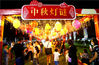 2021年9月15日，江苏苏州，游人在冯梦龙村中秋灯会的灯谜廊赏灯猜谜。