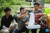 Zhou Zhan (C), Zheng Yi (L) and Lin Guihai, college students from China Agricultural University, check an autopilot sprayer in Future Orchard in Xiying Village of Yukou Township in Pinggu District of Beijing, capital of China, Aug. 25, 2021. 