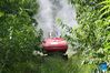 Lin Guihai, a college students from China Agricultural University, checks an autopilot sprayer in Future Orchard in Xiying Village of Yukou Township in Pinggu District of Beijing, capital of China, Aug. 25, 2021. 