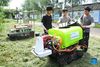 Zhou Zhan (C), Zheng Yi (L) and Lin Guihai, college students from China Agricultural University, check an autopilot sprayer in Future Orchard in Xiying Village of Yukou Township in Pinggu District of Beijing, capital of China, Aug. 25, 2021. 