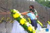 An armed police officer and a pupil pay tribute to martyrs in front of the memorial wall of Chinese People's Volunteers (CPV) martyrs at the CPV martyrs' cemetery in Shenyang, northeast China's Liaoning Province, Sept. 3, 2021. The remains of 109 Chinese soldiers killed in the 1950-53 Korean War were laid to rest on Friday in Shenyang. (Xinhua/Yang Qing)