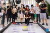 A staff member slides a curling stone on a movable sheet of ice during the 2021 China International Fair for Trade in Services (CIFTIS) in Beijing, capital of China, Sept. 3, 2021. (Xinhua/Zhang Yuwei)