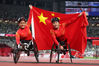 Silver medalist Hongzhuan Zhou (left) and gold medalist Fang Gao celebrate with the Chinese national flag after winning the women's 100m T53 final at the Tokyo Paralympics on Sept 1. [Photo/Agencies]