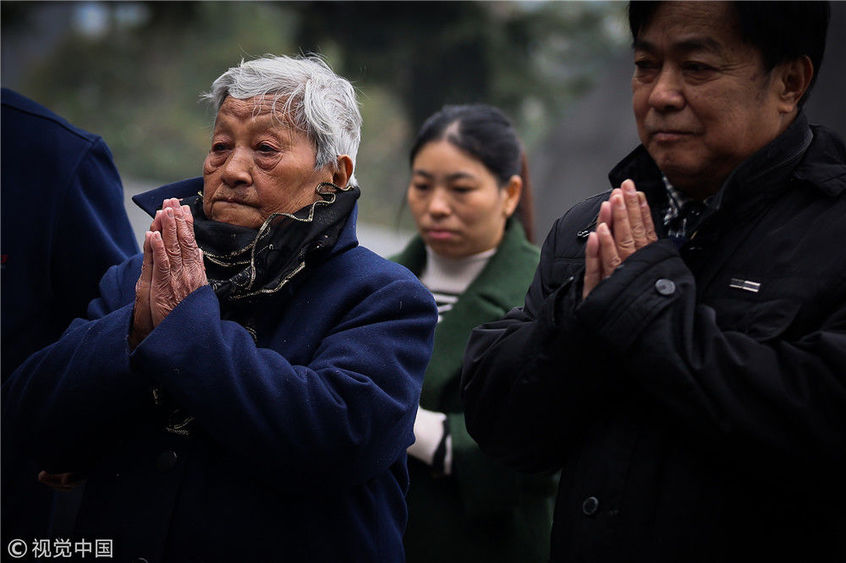 图为南京大屠杀幸存者仇秀英(左)祭拜遇难的家人.