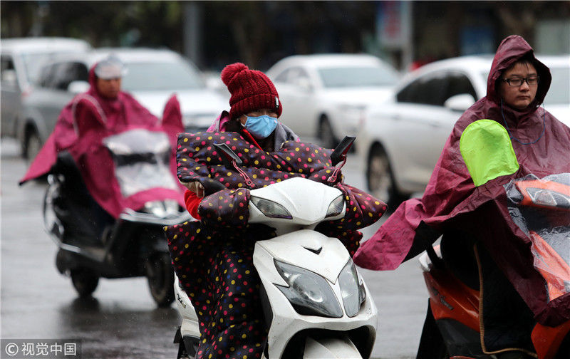 由于气温骤降,不少冒雨出行的市民穿上的厚冬装.